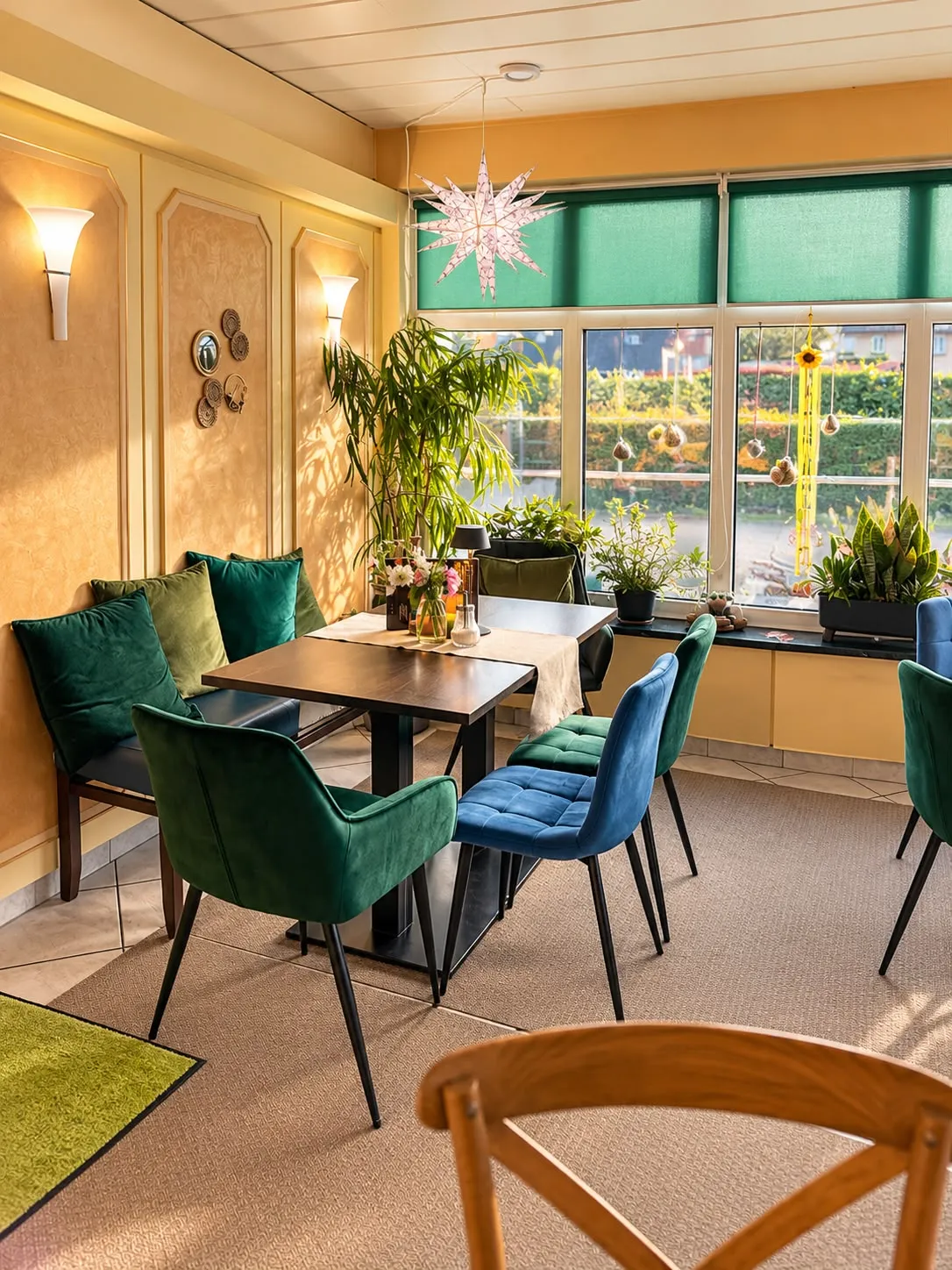 Wintergarten mit grünen Stühlen und Fensterfront